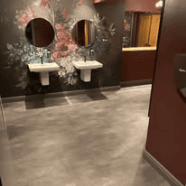 Commercial washroom with easy-clean flooring installed around the vanity area