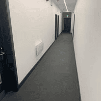 Dark commercial carpet fitted along an office corridor
